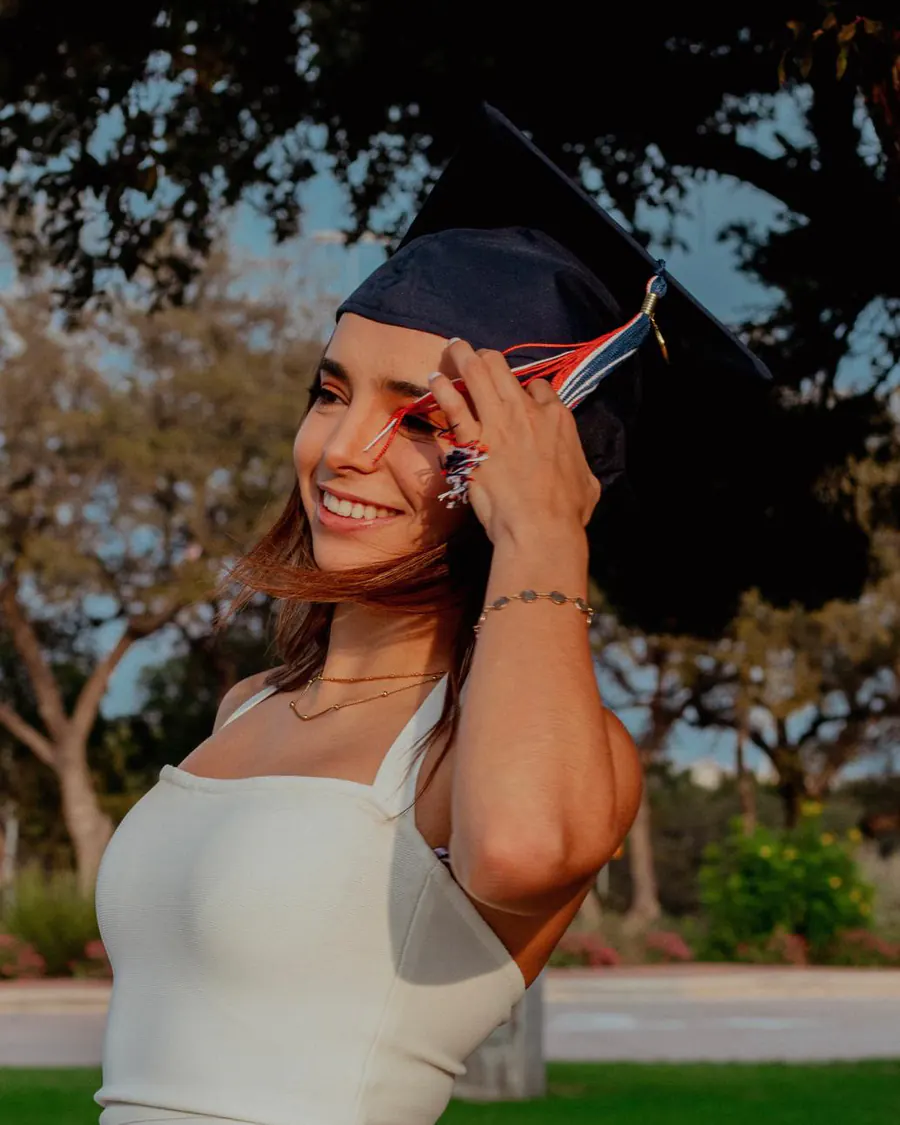 Natalia turning her graduation cap tassel at golden hour